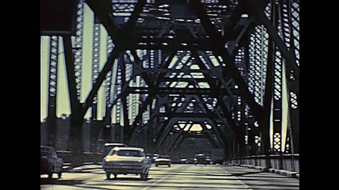 POV of vintage car crossing Oakland Bay Bridge passing by Treasure Island to Oakland. Archival footage in eighties. San Francisco, California, United States in 1980.
