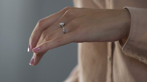Stressed lady with shaking hands taking off ring, divorce, relations break up