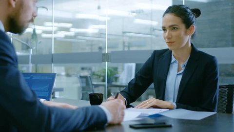 In the Office Businesswoman and Businessman Have Conversation, Negotiating, Draw up a Contract, Sign Documents, Finish Transaction, Shake Hands. Stylish People in Modern Conference Room. 4K UHD.