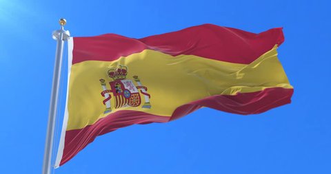 Spain flag waving at wind with blue sky in slow, loop
