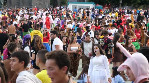 SANTA CRUZ DE TENERIFE - FEB 11, 2018: Big crowd of young people hang out in festival city center public square on carnival days wearing bizarre costumes and make-up