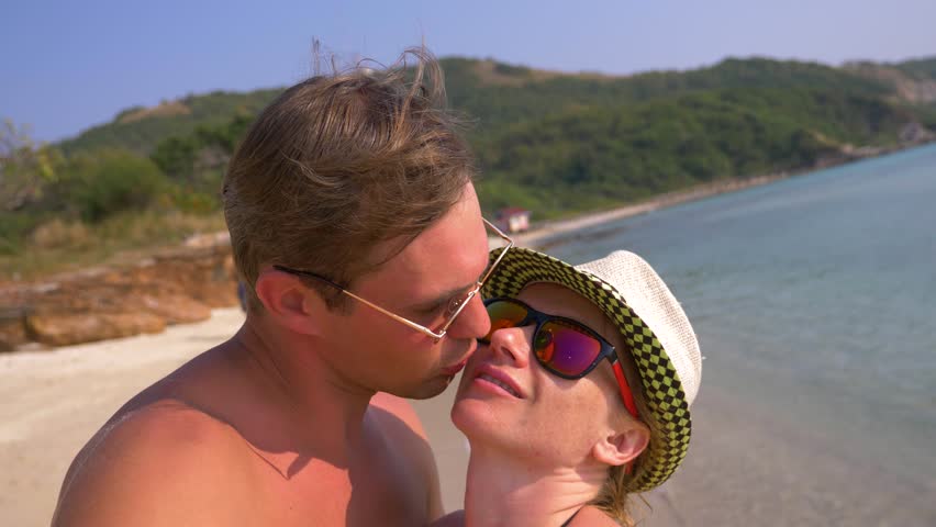 Couple of lovers kissing on the beach on a clear sunny day. 4k, slow motion