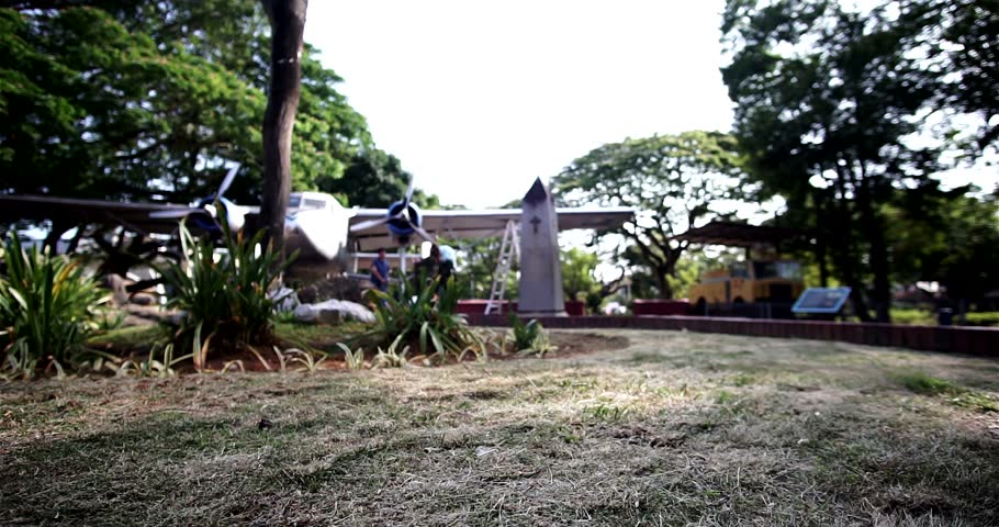 Dry brown carpet grass with background of old non functioning aeroplane park at the centre of Afamosa Melaka Malaysia with  panning left to right.