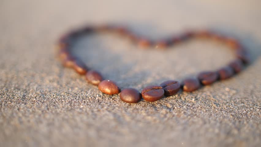 
Heart laid out of grains on sand with a shallow depth of field
