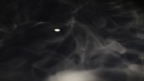 Smoke billowing over a black background