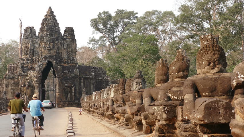 Group of cyclists on the background of the main gate of ancient Angkor Wat temple in Cambodia. Royalty-Free Stock Footage #1008012682
