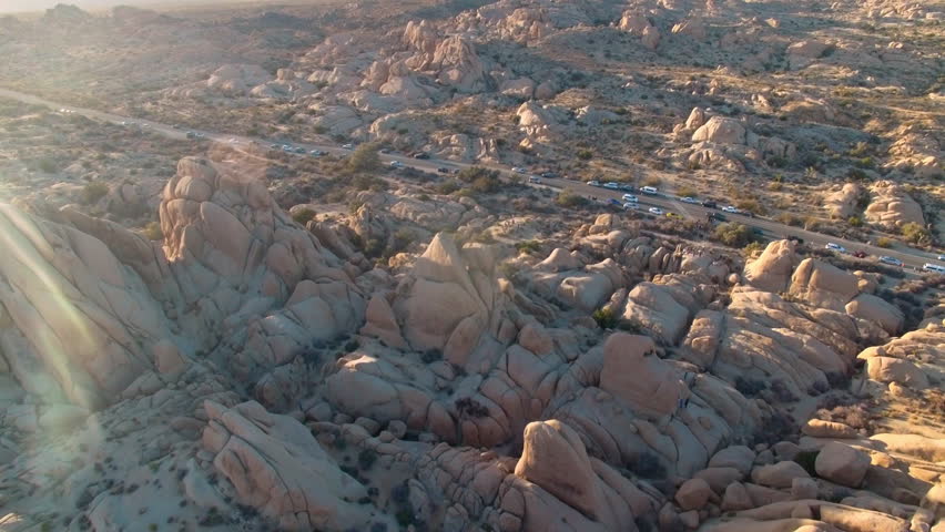 Sun shines brightly as drone circles above Hall of Horrors rock formations in Joshua Tree National Park
