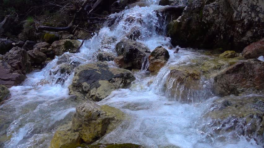 SLOW MOTION: flowing water over stones in mountines river