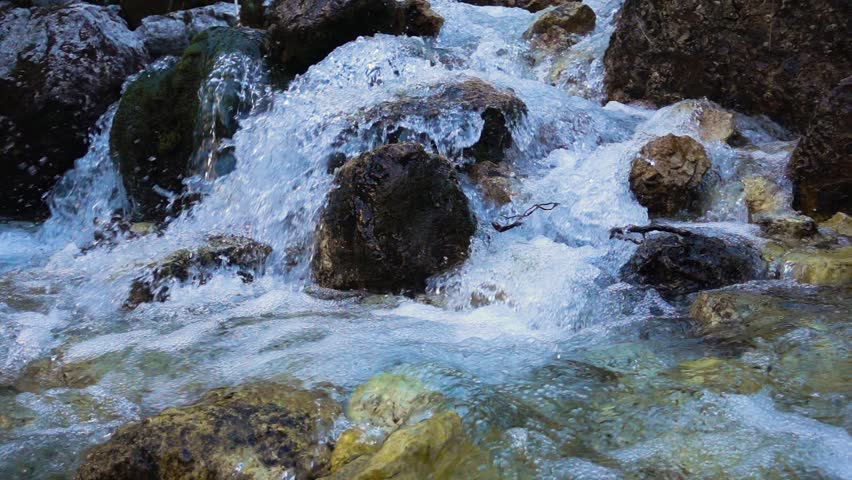SLOW MOTION: flowing water over stones in mountines river