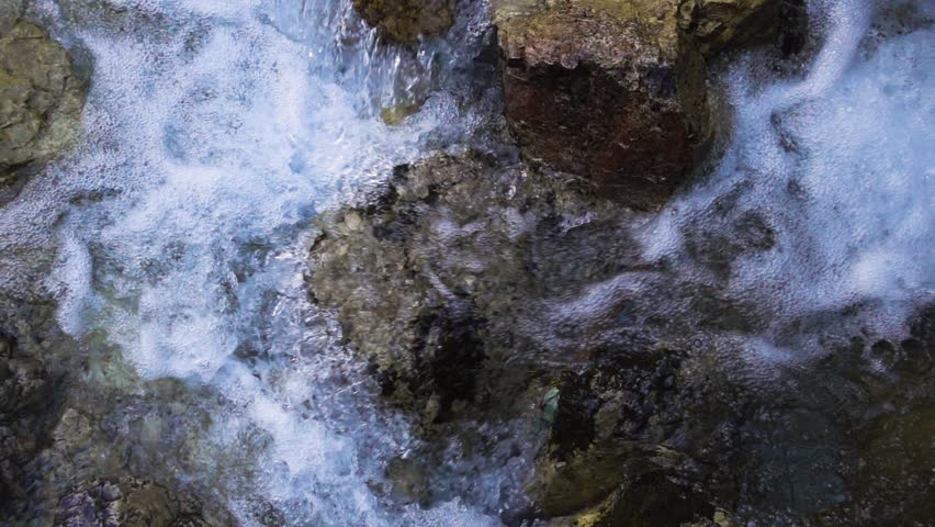 SLOW MOTION: flowing water over stones in mountines river
