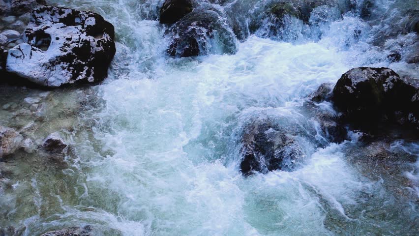 SLOW MOTION: flowing water over stones in mountines river