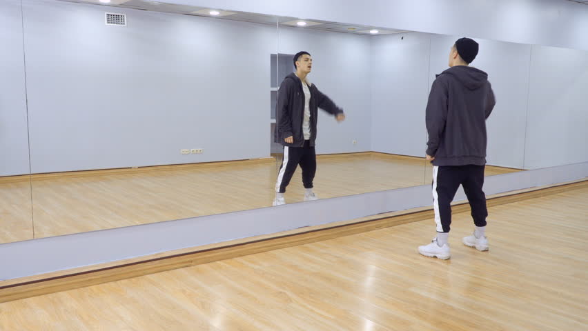 A lot of people dances in front of the mirror in light studio