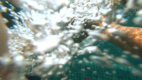 A young white handsome male doing an underwater selfie on an action camera. Portrait of a young man with glasses taking himself off to the camera under water. 4k