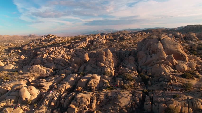 Aerial view circling above rock formations in Joshua Tree National Park during golden hour