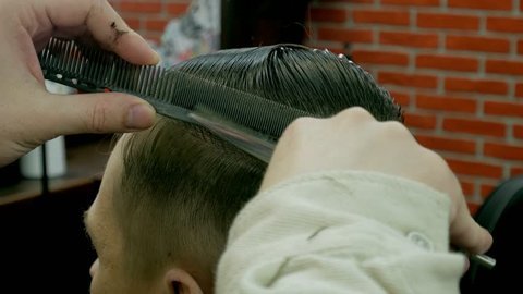 Barber cuts the hair of the client with scissors 4k