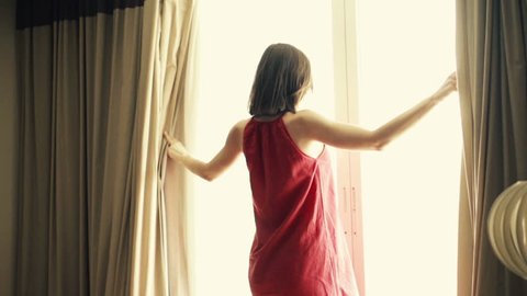 Woman unveil curtains in room, super slow motion, 240fps
