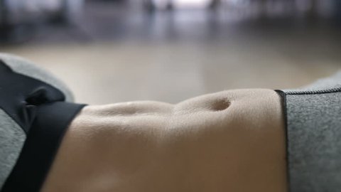 Extreme close-up of woman doing abdominal exercise indoors. Sporty female in sportswear top doing crunches at home on the floor. Sit ups as best exercise for abs.