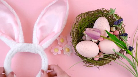 Happy Easter overhead with Easter eggs, bunny ears and decorations on a wood table background time lapse,