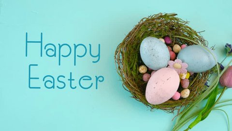 Happy Easter overhead with Easter eggs and decorations on a wood table background, with animated text.