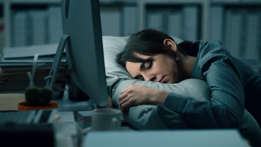Tired exhausted office worker sleeping on the desk at work: she is waking up, yawning and checking the computer | Shutterstock HD Video #1008065368