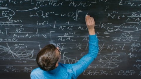 High-Angle Shot of a Brilliant Young Student Writing Complex Mathematical Formula/ Equation on the Blackboard. Shot on RED EPIC-W 8K Helium Cinema Camera.