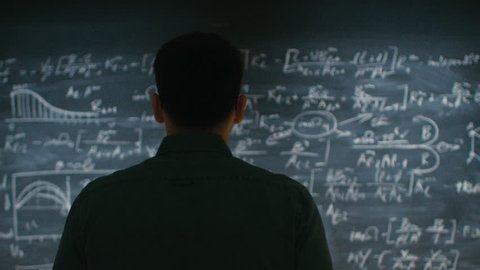Brilliant Young Academic Approaches Blackboard with Complex Mathematical Formula Written on it, Starts Thinking about Solution. Shot on RED EPIC-W 8K Helium Cinema Camera.