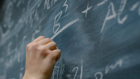 Hand Holding Chalk and Writing Complex and Sophisticated Mathematical Formula on the Blackboard. Underlining Equation. Shot on RED EPIC-W 8K Helium Cinema Camera.