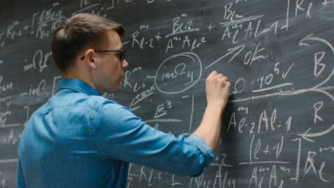 Brilliant Young Academic Finishes Writing Big and Complex Mathematical Formula/ Equation on the Blackboard. Shot on RED EPIC-W 8K Helium Cinema Camera.