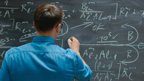 Following Close-up Shot of the Hand Holding Chalk and Writes Complex Mathematical Formula/ Equation on the Blackboard. Shot on RED EPIC-W 8K Helium Cinema Camera.