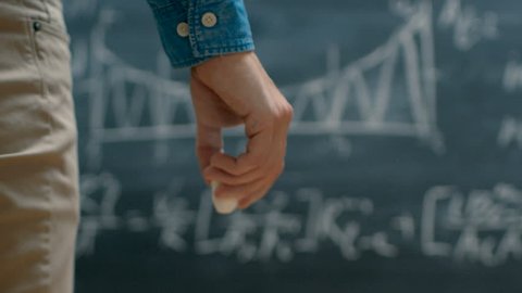 Brilliant Young Academic Finishes Writing Complex Mathematical Formula/ Equation on the Blackboard. Shot on RED EPIC-W 8K Helium Cinema Camera. Shot on RED EPIC-W 8K Helium Cinema Camera.