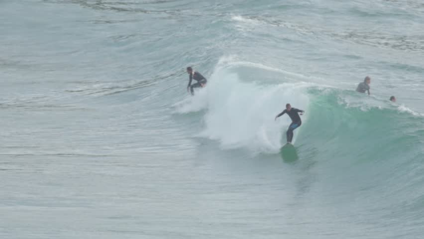 surfers in water waiting for wave at beach 4k
