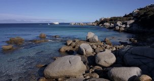 4K high quality aerial summer afternoon footage of Western Cape's coast, Simon's Town beach boulders, salt water, sandy sea front, Atlantic Ocean views in the background near Cape Town, South Africa