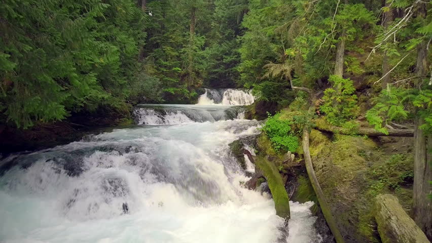 Aerial shot of amazing an amazing waterfall and moss covered rocks in Oregon.