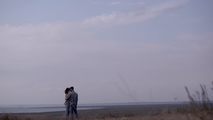 Couple hugs at the edge of a cliff