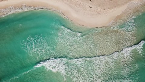 Top view of beautiful beach. Aerial drone shot of turquoise sea water at the beach. Caribbean seaside beach with turquoise water and big waves aerial view. 