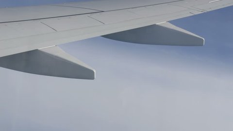 The wing of the plane flies over the clouds