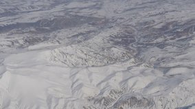 Aerial and video shooting of snow-capped Caucasian mountains from an airplane