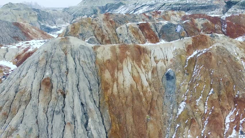 Success leadership, achievement and people concept - young guy with flag on mountain top. Footage. Man with a flag on top of a mountain