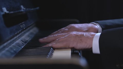 Hands of an old man playing the piano