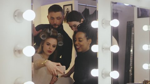 Beauty models together stylist making selfie photo before fashion show in makeup room. Professional makeup and hairdressing for fashion model