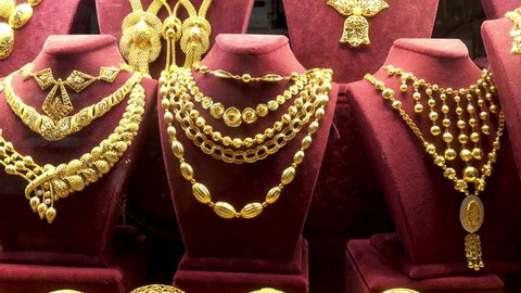 4K view of a set of gold necklaces, chains and bracelets in a showcase of a jewelry store