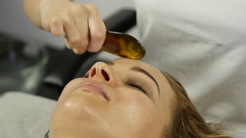 Beautiful woman has a acupressure on a face with scraper gouache. Chinese alternative medicine