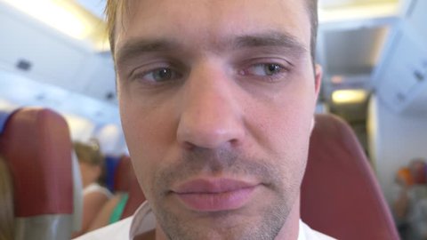 4k, close-up. A man's face during an airplane flight experiencing aerophobia.