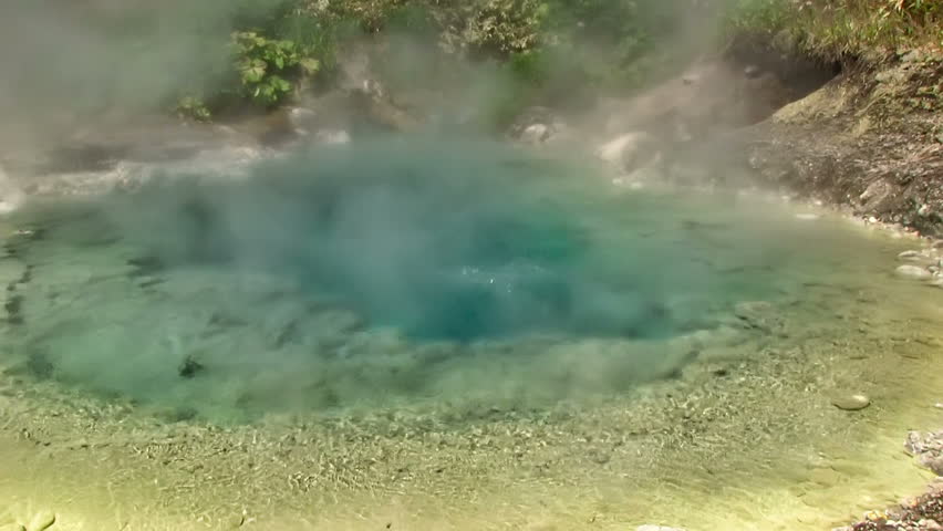 White vapor rises above the hot springs on the slope of the volcano. Kuril Islands, Itutrup Island, Baranskiy Volcano