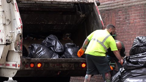 DSNY loading trash bags into garbage truck in downtown New York City, New York June 6, 2016 taken in 4k/UHD resolution.