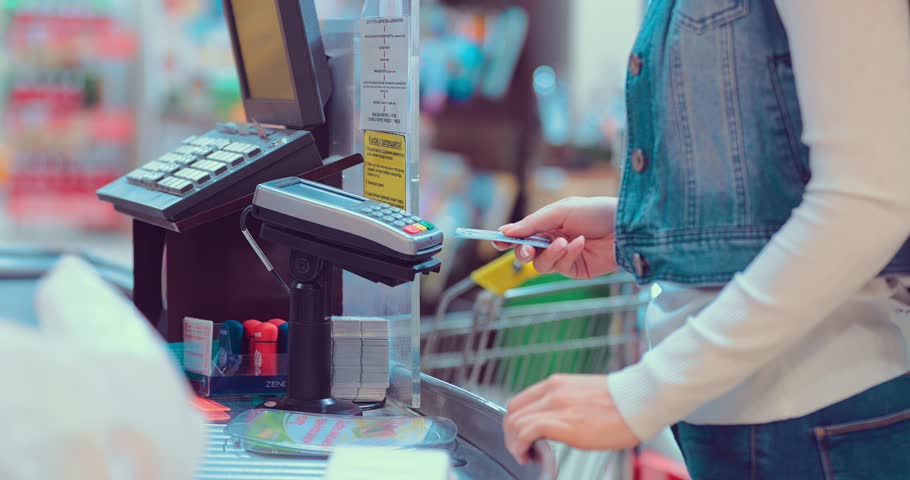 Customers buying food and staples from a cashier and paying at the till. Supermarket store. Close-up Royalty-Free Stock Footage #1008145540