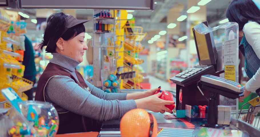 Young female at the cash desk ringing products up Royalty-Free Stock Footage #1008145717