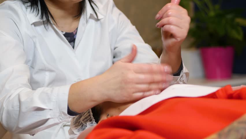 Cosmetologist is going face mask . peeling for young woman. Young woman is having cosmetology procedure