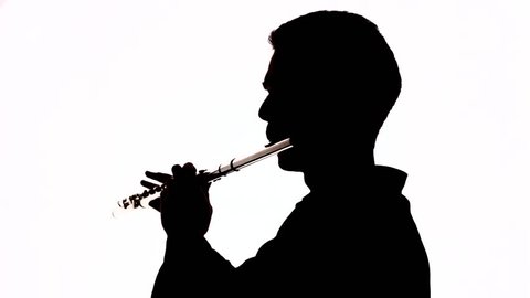 Isolated silhouette of a guy playing the flute. Black and white footage.