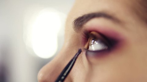 Close up slightly unfocused footage of applying and blending in eyeshadows. Process of creating flawless smokey eyes make up look.